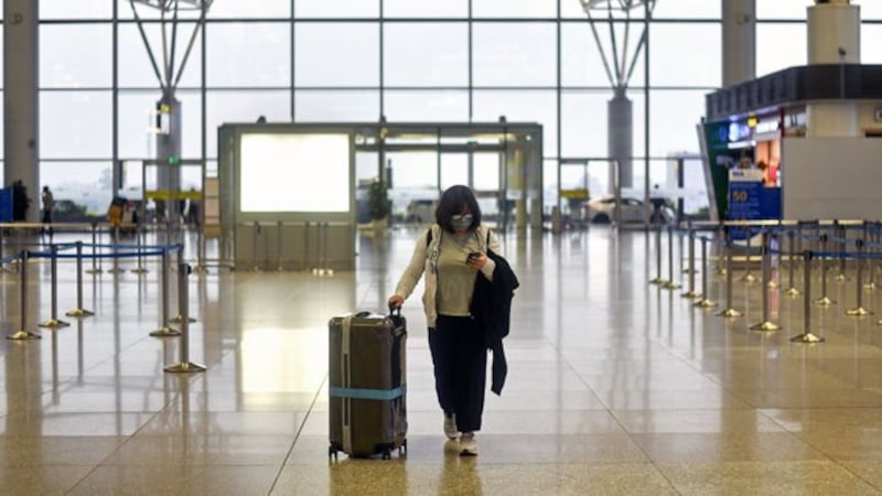 A passenger wearing a face mask walks through the nearly empty departure hall at Noi Bai International Airport in Vietnam's capital Hanoi, March 12, 2020.