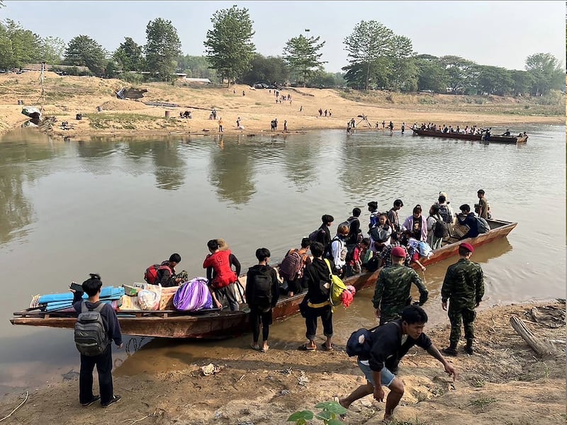 People from Myanmar cross the Moei river on the Thai-Myanmar border on April 11, 2023.