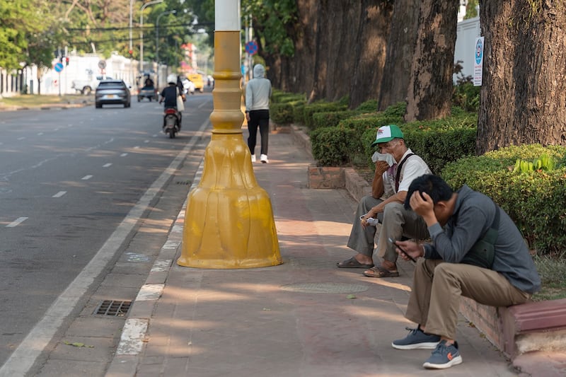 People rest along a road in Vientiane, May 1, 2024 as Laos suffers under sweltering temperatures. (Kaikeo Saiyasane/Xinhua via Getty Images)