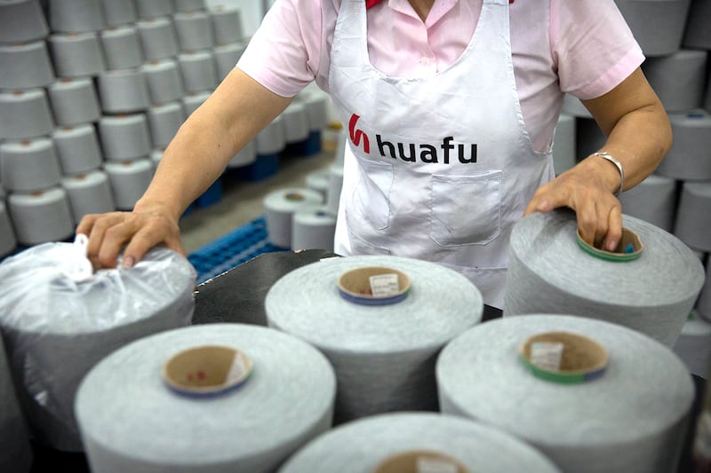 A worker packages spools of cotton yarn at a Huafu Fashion plant in Aksu in western China's Xinjiang Uyghur Autonomous Region, April 20, 2021.  (AP Photo/Mark Schiefelbein)