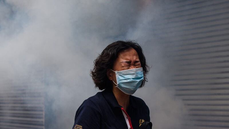 A woman reacts after riot police fired tear gas to disperse protesters taking part in a pro-democracy rally against a proposed new security law in Hong Kong, May 24, 2020.