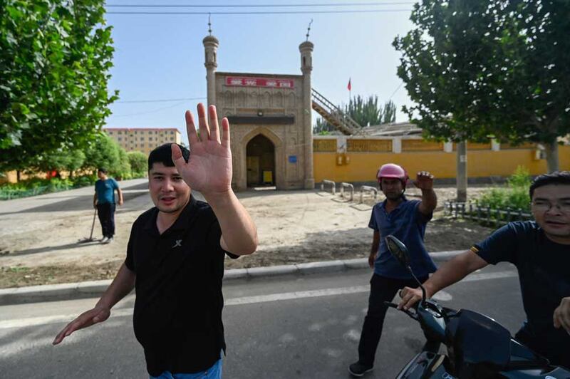 Local people try to prevent the taking of a photo outside a mosque in Azatbagh village, outside Yarkant in northwestern China's Xinjiang region. Credit: Pedro PARDO / AFP