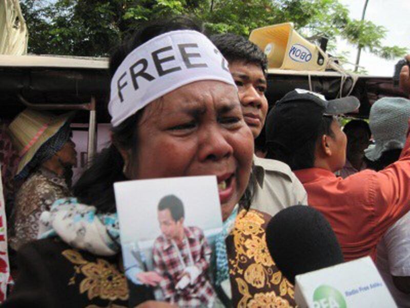 A mother of one of the 21 detainees cries as she holds a photo of her son while protesting outside the Appeals Court in Phnom Penh, Feb. 11, 2014. Photo credit: RFA.