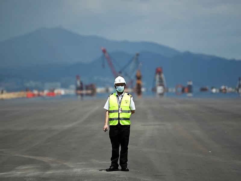 A security guard stands on the tarmac of the completed third runway at Chek Lap Kok airport, Hong Kong, Sept. 7, 2021.