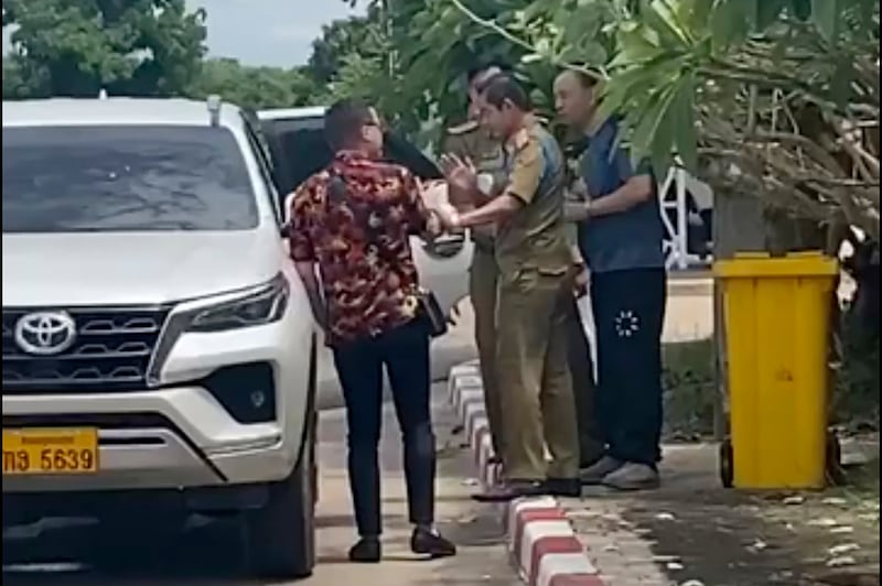 An activist, left, traveling with Chinese rights lawyer Lu Siwei, right, argues with police who were in the process of detaining Lu, near the Thanaleng dry port, south of Vientiane, in July 2023. Lu Siwei has been repatriated to China after being arrested in Laos en route to join his family in the United States. Credit: Anonymous Source via AP)