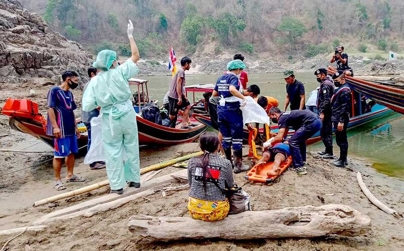 An injured refugee is placed on a stretcher Tuesday before being taken to a hospital in Mae Sam Laep, Thailand, after crossing the Salween River. (AFP/Royal Thai Army)