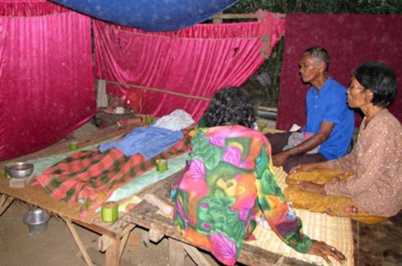 Family members keep vigil over the body of Tim Tuoy in Roka commune, March 2015. Credit: RFA