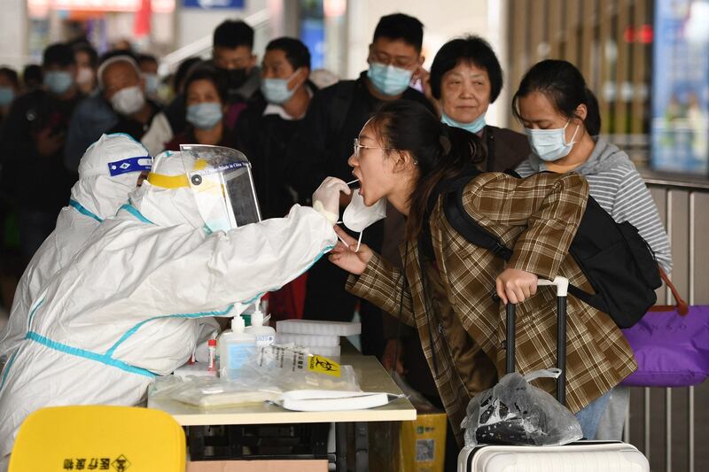 A passenger undergoes a test for COVID-19 as she arrives at the Nanjing Railway Station during the National Day holidays in Nanjing in China's eastern Jiangsu province, Oct. 6, 2022. Credit: AFP