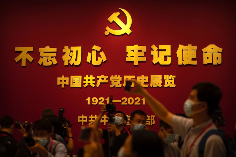 2021年6月25日，在北京新落成的中国共产党博物馆，游客和记者在标有“不忘初心、牢记使命”的标语展品前合影留念。（美联社）