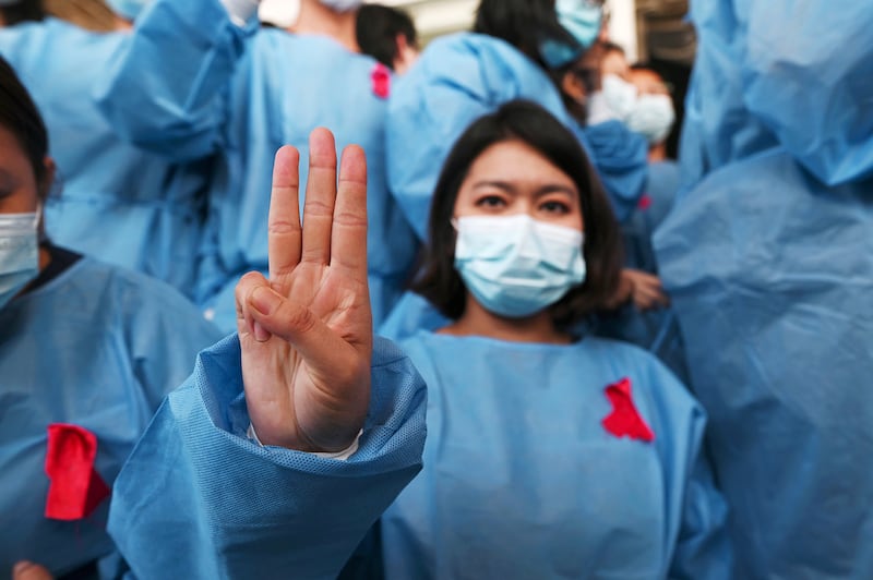 A medical worker wears a red ribbon during a protest against the coup that ousted elected leader Aung San Suu Kyi, at Yangon General Hospital, in Yangon, Myanmar Feb. 3, 2021.