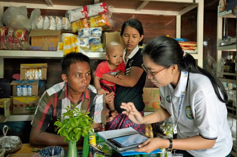 A census enumerator (R) fills out information about a family in Myanmar's capital Naypyitaw, Oct. 1, 2024. (Aung Shine Oo/AP)