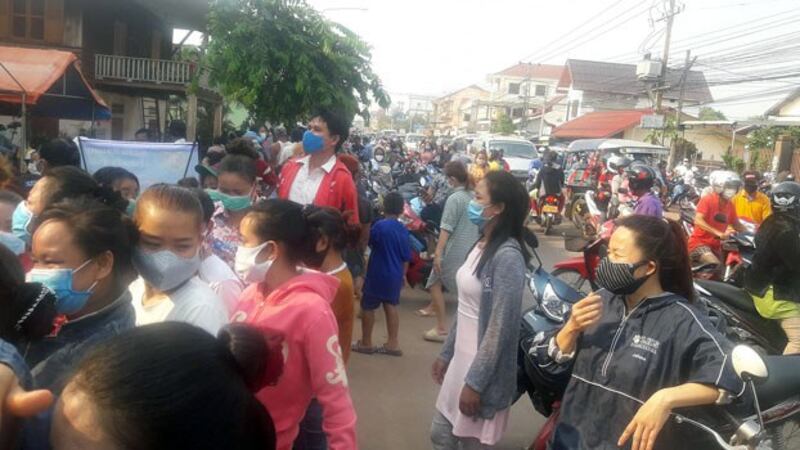 People gather to pick up packages of donated food during the Lao New Year in Dondeng village, Chanthabouly district, in the capital Vientiane, April 14, 2020. 