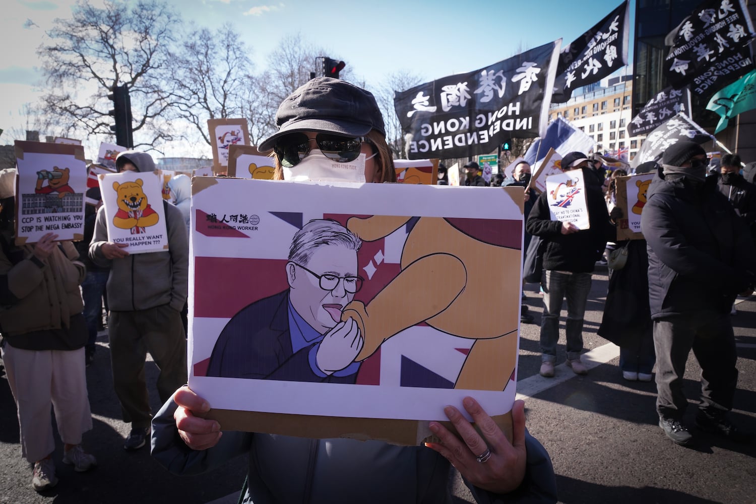 Ein Demonstrant enthält ein Schild, das den britischen Premierminister Keir Starrer und Winnie the Pooh darstellt, das den chinesischen Präsidenten Xi Jinping am vorgeschlagenen Standort der chinesischen „Mega-Embassy“ in London am 15. März 2025 vertritt.