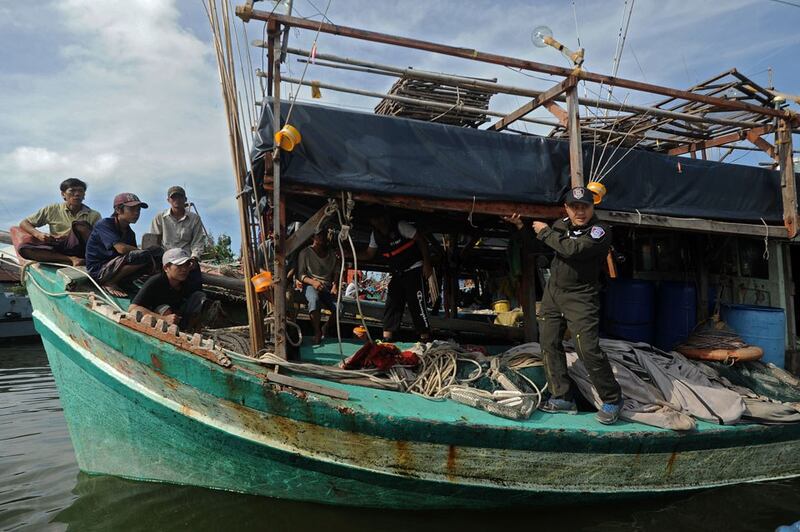 Hình minh họa. Các ngư dân Việt Nam (trái) đang ngồi trên tàu sau khi họ bị Cảnh sát Biển Thái Lan (phải) bắt giữ ở tỉnh Narathiwat hôm 14/2/2016