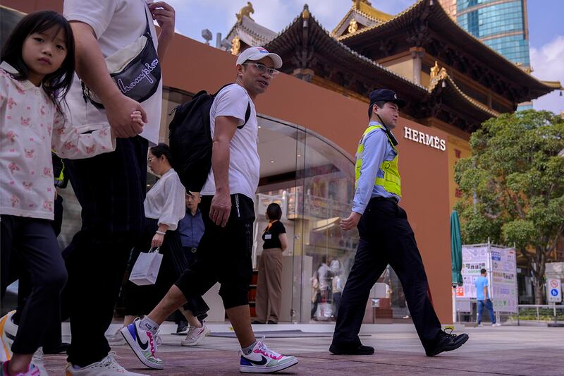 2024年10月12日，上海市的热门购物景点静安寺附近，一家精品店前来往的游人。(美联社)