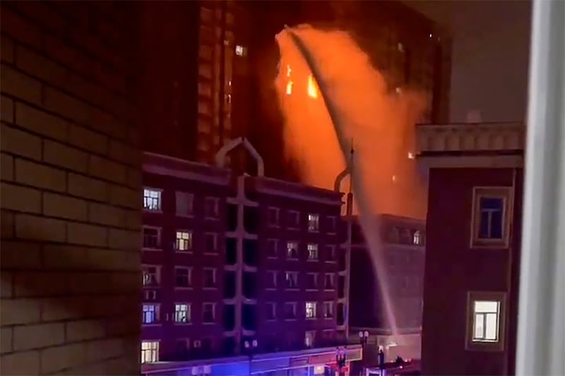 Firefighters spray water on a fire at a residential building in Urumqi in China's Xinjiang region, Nov. 24, 2022.