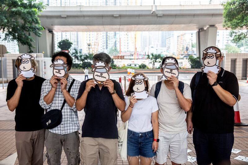 Supporters of a pro-democracy union pose with illustrations of sheep outside West Kowloon Court in Hong Kong, July 23, 2021. AFP