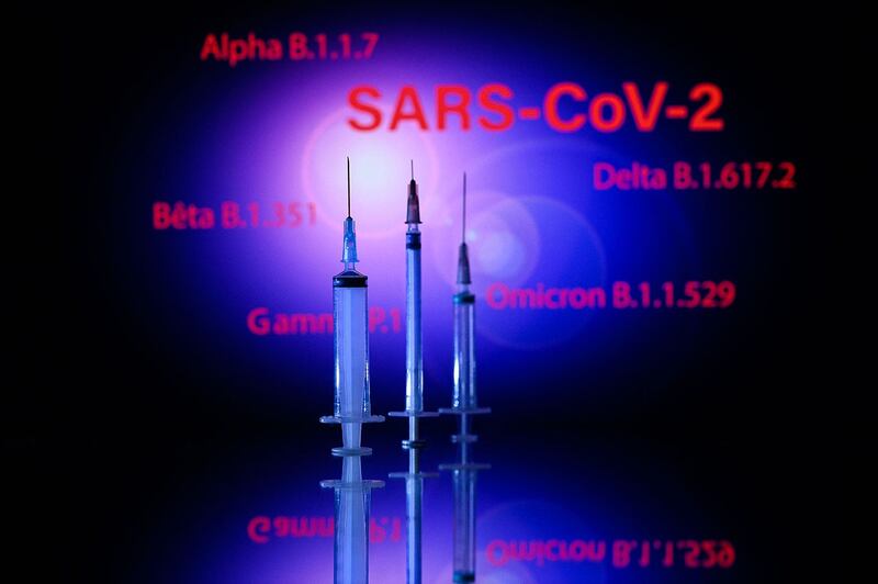 图片展示注射器和 SARS-Cov-2 电源变体的屏幕：Alpha、Beta、Delta、Gamma 和 Omicron。（法新社）