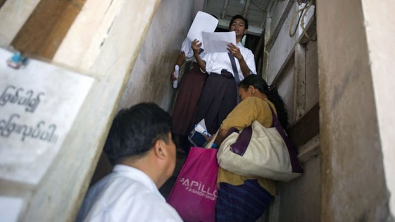 Members of the National League for Democracy check voter lists during a door-to-door visit as part of a voter education campaign in Yangon, June 29, 2015.