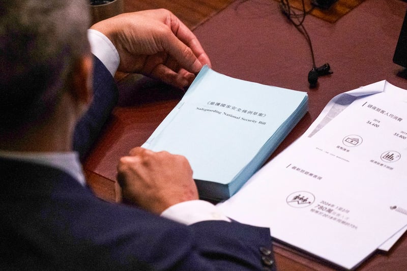 A lawmaker holds a copy of the proposed Safeguarding National Security Bill at the Legislative Council in Hong Kong, March 19, 2024. (Louise Delmotte/AP)