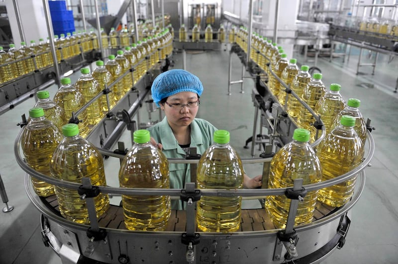 An employee works at the production line of an edible oil company in Sanhe, Hebei April 12, 2011. (Reuters)