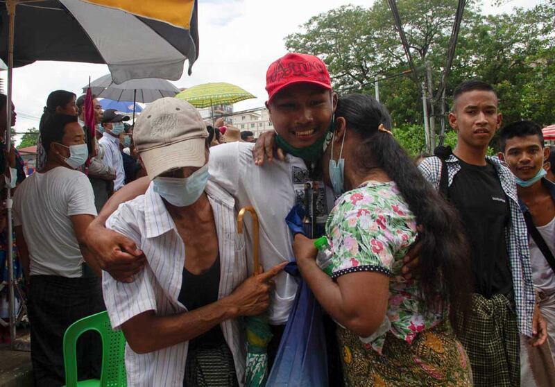 A released prisoner reacts with his relatives outside the Insein Prison. (Reuters)