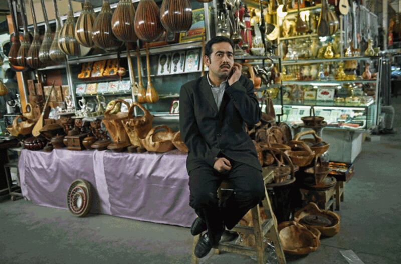 A Uyghur vendor makes a phone call while tending to his shop at a bazaar in Kashgar, in northwestern China's Xinjiang region, April 19, 2015. Credit: AFP