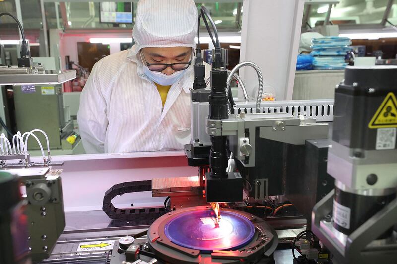 An employee makes chips at a factory owned by Jiejie Semiconductor Company in Nantong, in eastern China's Jiangsu province, March 17, 2021. Credit: AFP