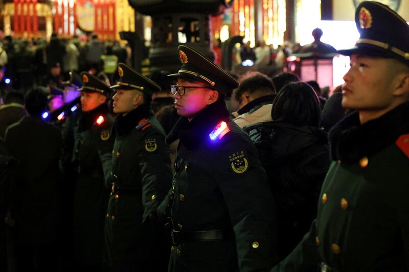 Police officers form a line to control traffic before a mass prayer starts at Jade Buddha Temple on Lunar New Year's Eve in Shanghai, China, Jan. 28, 2025.