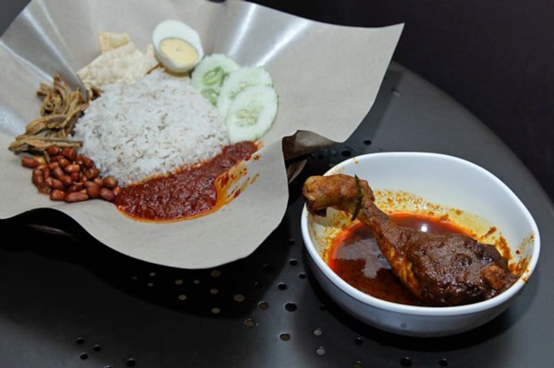 Malaysia's favorite breakfast dish, Nasi Lemak (L), which is a rice meal, is placed on a table with another dish, Chicken Rendang, at a restaurant in Subang Jaya, Malaysia, April 3, 2018. Credit: Sadiq Asyraf/AP