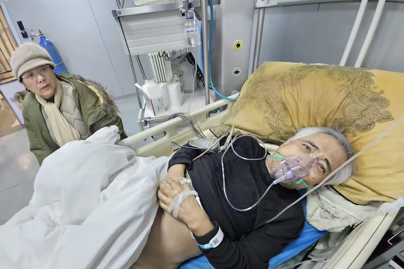 Ethnic Mongolian dissident Hada lies in a bed, next to his wife Xinna,while on a respirator in the Affiliated Hospital of Inner Mongolia Medical University in Hohhot, China's Inner Mongolia Autonomous Region.