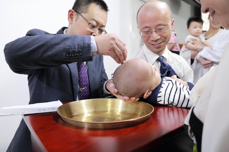 资料图片：秋雨教会被关押中的王怡牧师（左）过去为小文施洗。（廖强提供）