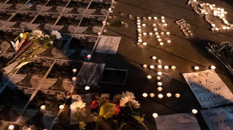 香港中文大学民主女神像被拆后，中大师生在女神像原址空地上放下鲜花、点上烛光悼念。(AFP)