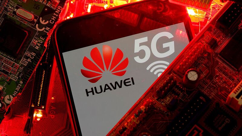 资料图片：PC 主板上带有华为和 5G 网络标志的智能手机。（路透社）