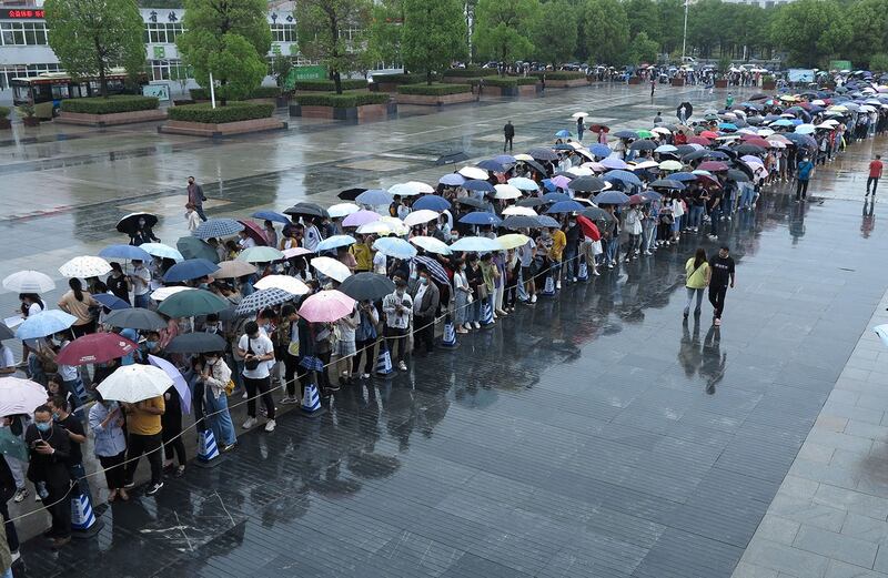 2021年5月15日，安徽省阜阳市的疫苗接种点外，民众在雨中排队等侯接种新冠病毒疫苗。（路透社）