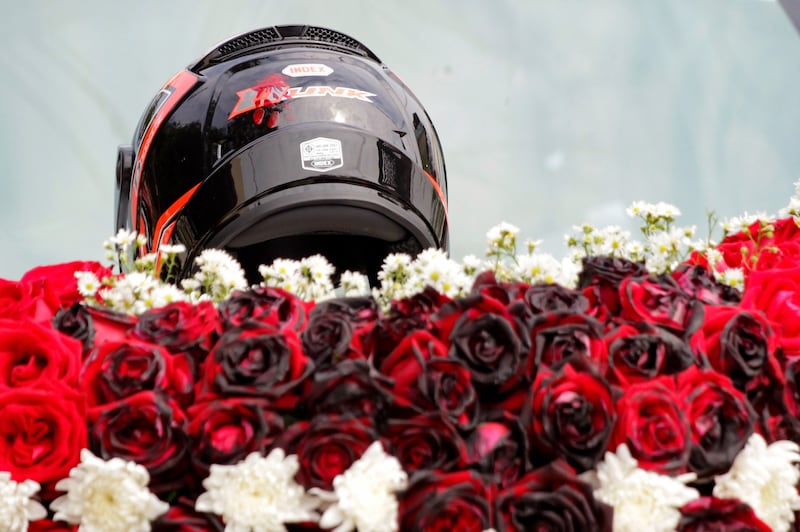 The bullet-pierced motorbike helmet of slain protester Mya Thwe Thwe Khine, adorns her funeral floral display in Naypyidaw, Feb. 21, 2021.