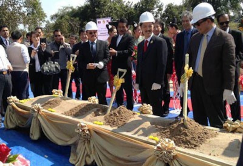 Officials use shovels to ceremoniously break ground on the Savannakhet-Lao Bao railway project, Dec. 18, 2013.