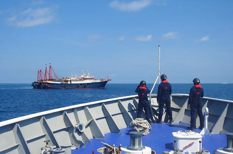 Philippine coastguard personnel aboard their ship BRP Cabra monitoring Chinese vessels anchored at Sabina Shoal, a South China Sea outcrop claimed by Manila, April 27, 2021. Credit: Philippine Coastguard via AFP