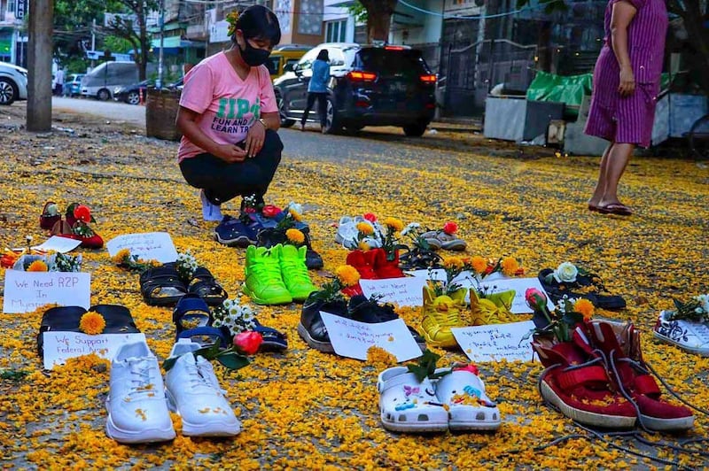 A woman looks at a tableau of shoes in Yangon's Myaynigone township. (AFP/Handout)