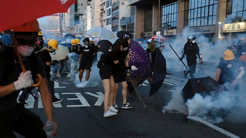 2019年7月28日，游行的香港民众试图躲避警察发射的催泪弹。（美联社）