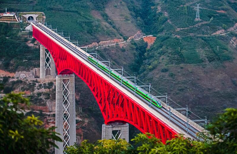 An electric train of China-Laos Railway crosses a bridge over the Yuanjiang River in southwestern China's Yunnan Province in 2021. According to the World Bank's latest estimates, Laos' national debt has probably surpassed 110 percent of GDP, with more than two-fifths of that owed bilaterally to China. Credit: Wang Guansen/Xinhua via AP