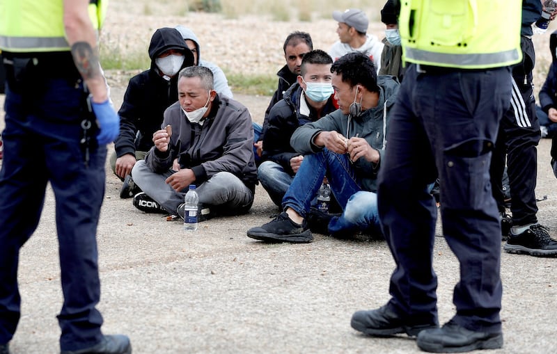 Migrants sit by the beach after being rescued by the RNLI in the English Channel, following their departure from northern France. Credit: Reuters