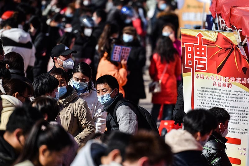 2023年1月29日，安徽省阜阳市参加招聘会。有分析指出，两项数据此消彼长昭示着学历崇拜这一观念的退潮，也显示出中国年轻人在面临经济下行导致就业风险时，作出了追求安稳的集体选择。（法新社）