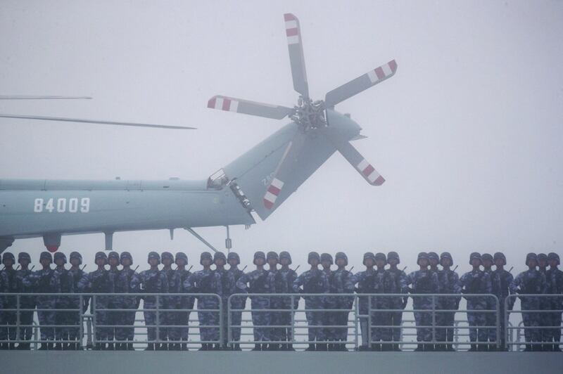 Soldiers stand on deck of the ambitious transport dock Yimen Shan of the Chinese People's Liberation Army (PLA) Navy as it participates in a naval parade to commemorate the 70th anniversary of the founding of China's PLA Navy in the sea near Qingdao in eastern China's Shandong province, April 23, 2019. Credit: AFP