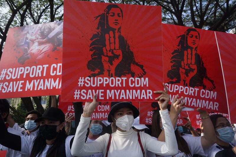 Protesters display signs supporting the Civil Disobedience Movement during a demonstration against the military coup in Yangon, Feb. 15, 2021. Credit: Sai Aung Main/AFP