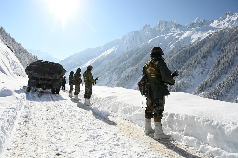 Indian army soldiers walk along a road near Zojila mountain pass that connects Srinagar to the union territory of Ladakh, bordering China Feb. 28, 2021. Credit: AFP