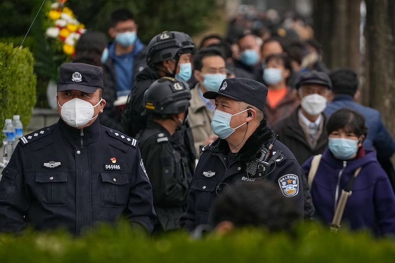 2023年4月5日清明节，警察和保安在北京一处墓地门口站岗。(美联社)