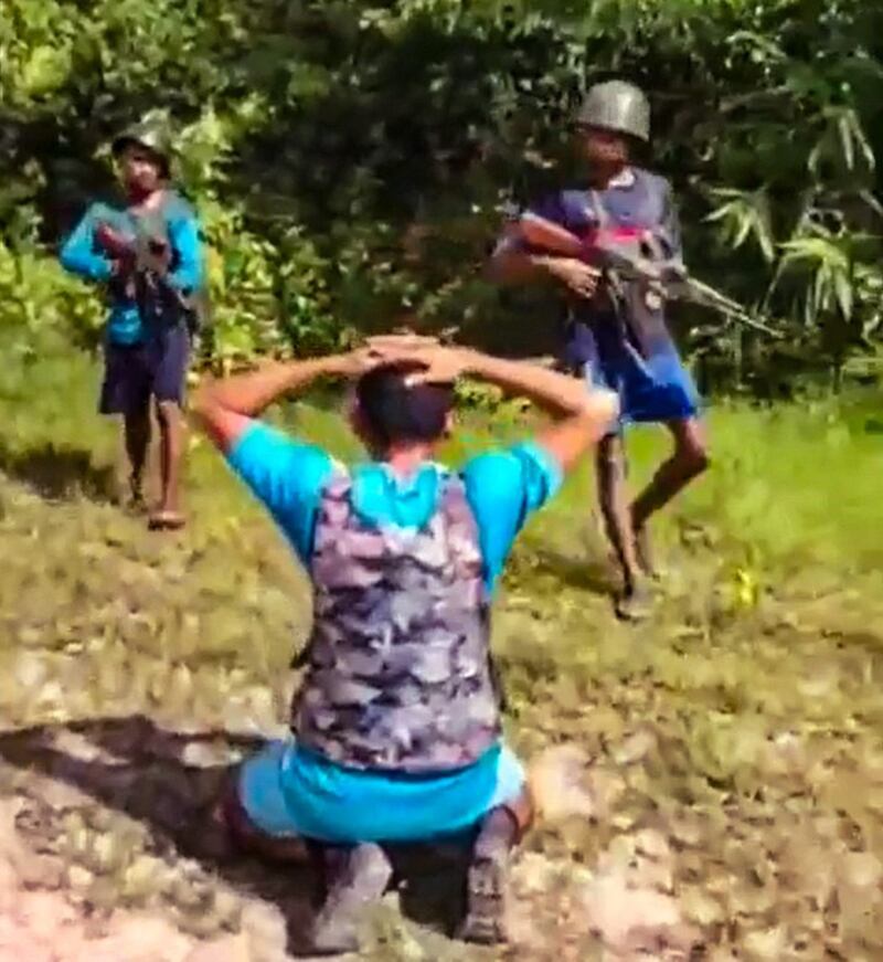 Arakan Army fighters guard one of the 14 junta soldiers captured after a firefight in Rakhine state's Maungdaw township, July 18, 2022. Credit: Screengrab from Arakan Princess Media video