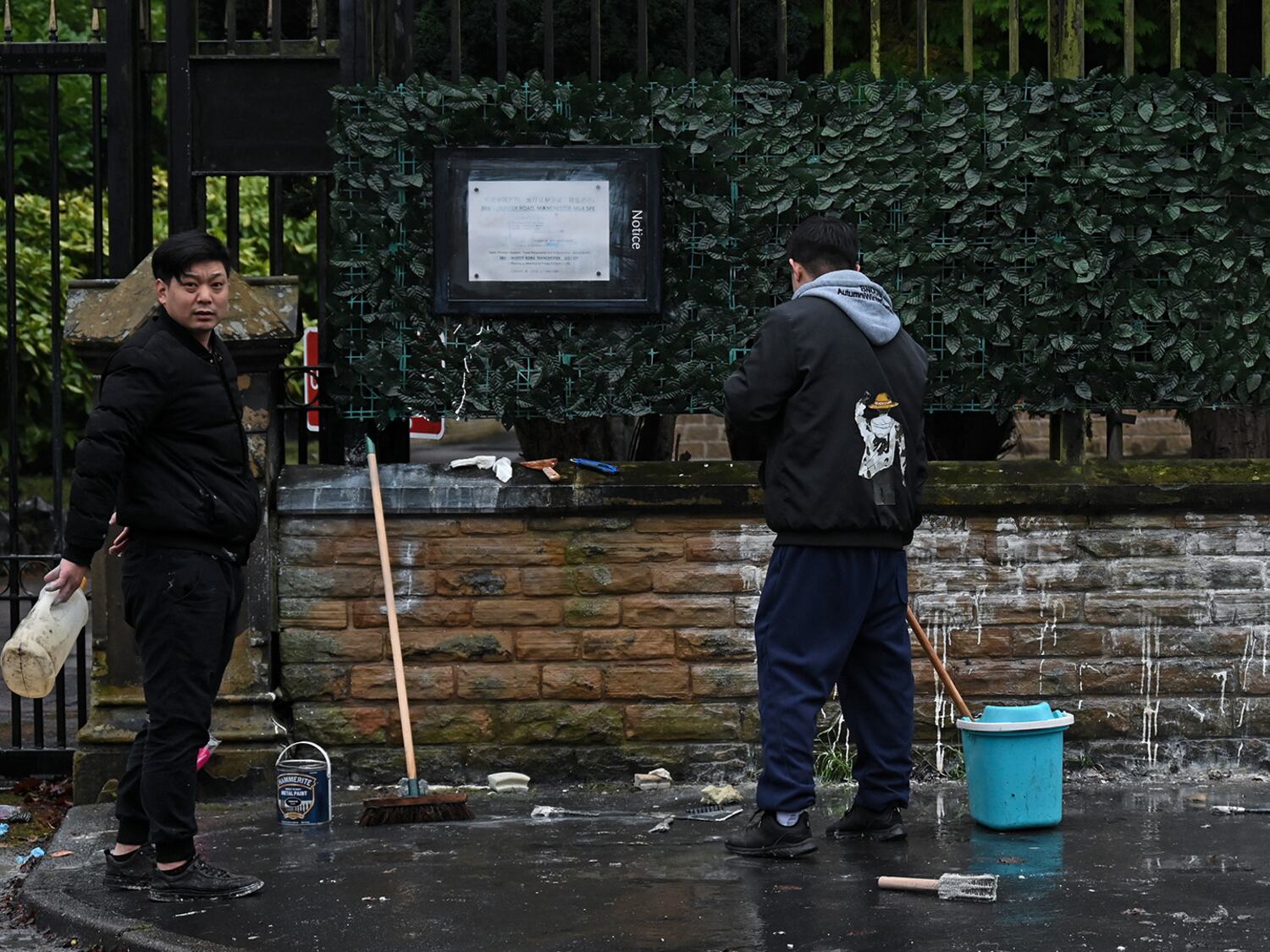 Workers clean the boundary walls of the Chinese consulate in Manchester after they were daubed with Hong Kong protest graffiti, Dec. 28, 2024.