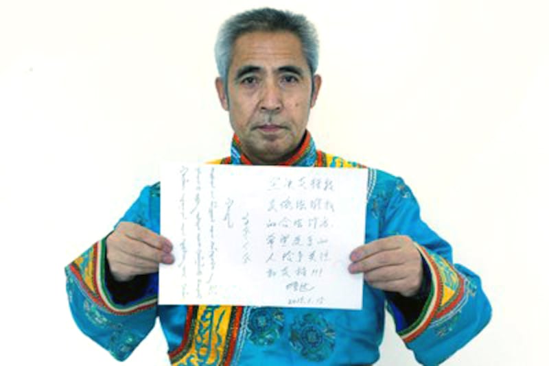 Mongolian dissident Hada displays a sign expressing support for herders in Mongolian and Chinese, Jan. 15, 2015.